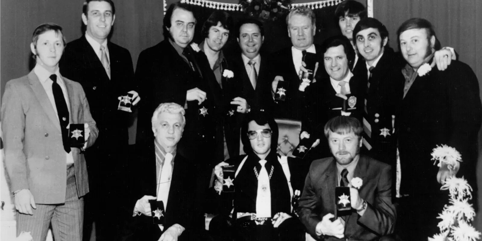 (L-R, standing) Billy Smith, former sheriff Bill Morris, Lamar Fike, Jerry Schilling, Sheriff Roy Nixon, Vernon Presley, Charlie Hodge, Sonny West, George Klein, Marty Lacker. (L-R, front) Dr. George Nichopoulos, Elvis Presley, and Red West.