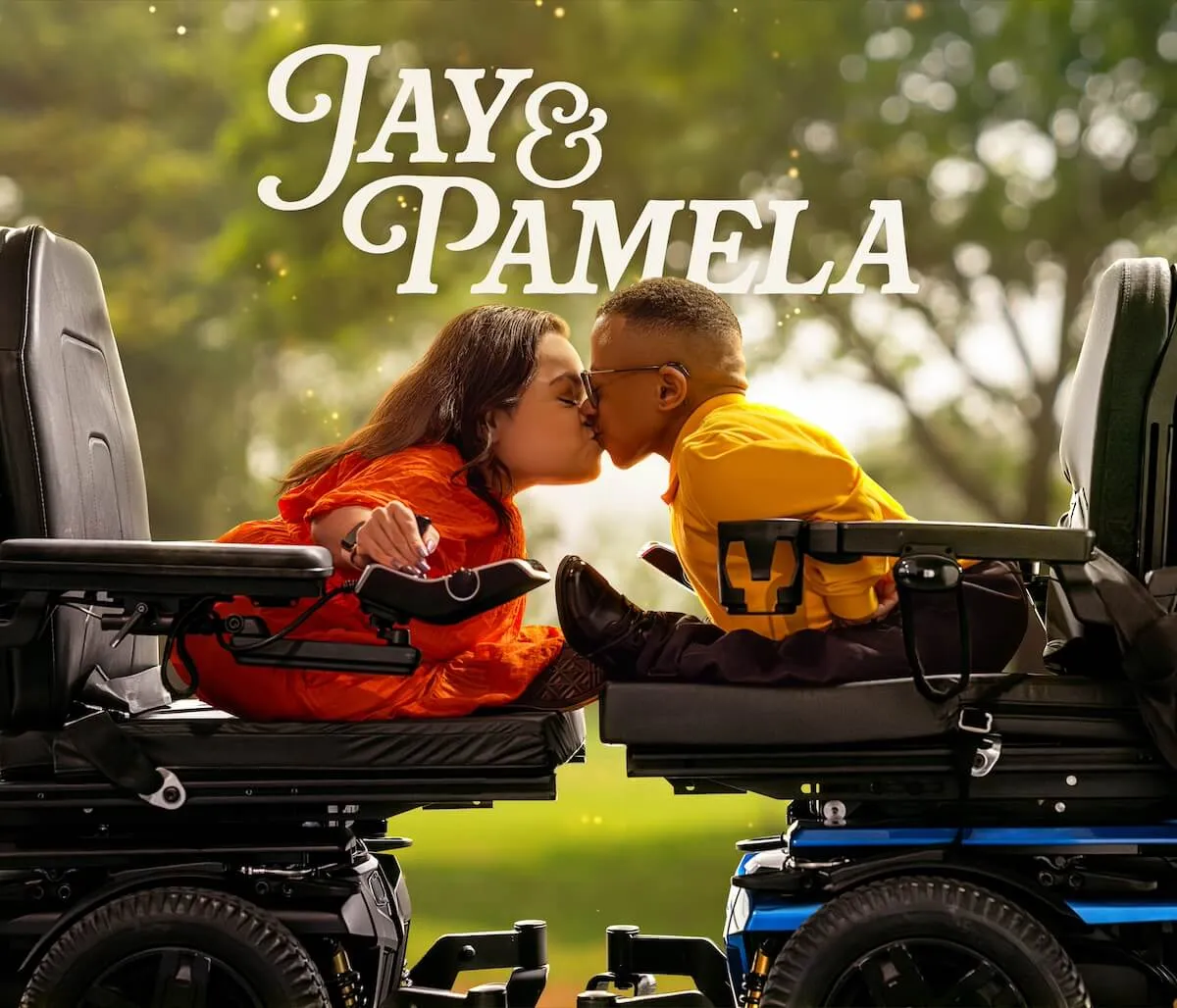 Pamela and Jay, both sitting in their wheelchairs, lean forward to kiss each other in the key art for the TLC series 'Jay & Pamela'