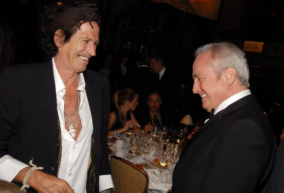 Keith Richards stands with Lorne Michaels. They are in front of a table.