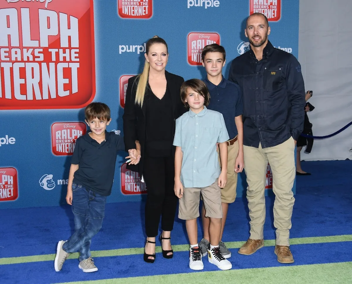 Standing with their three sons, Melissa Joan Hart and Mark Wilkerson smile at the Disney premiere of 'Ralph Breaks The Internet' in 2018