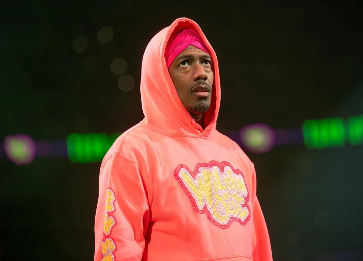 Nick Cannon posing in a pink sweater at the Wild 'N Out Live: The Final Lap Tour.