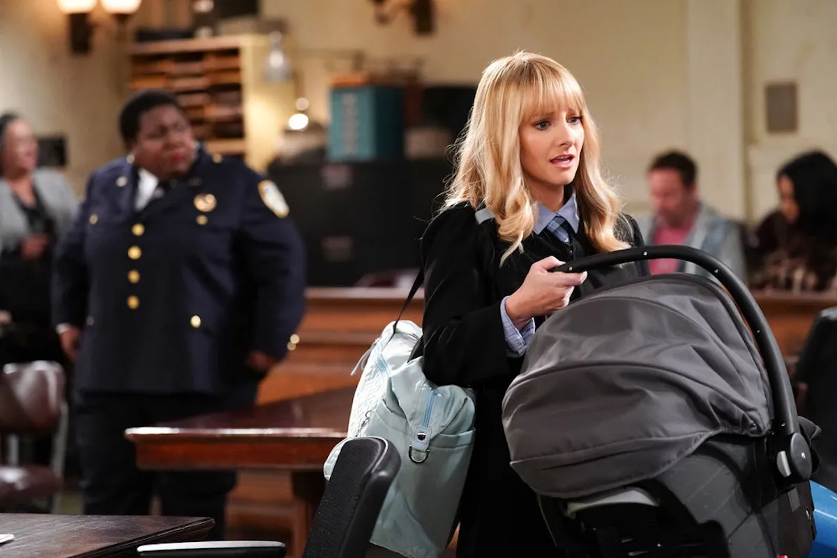 Melissa Rauch holding an infant carrier in 'Night Court' Season 3