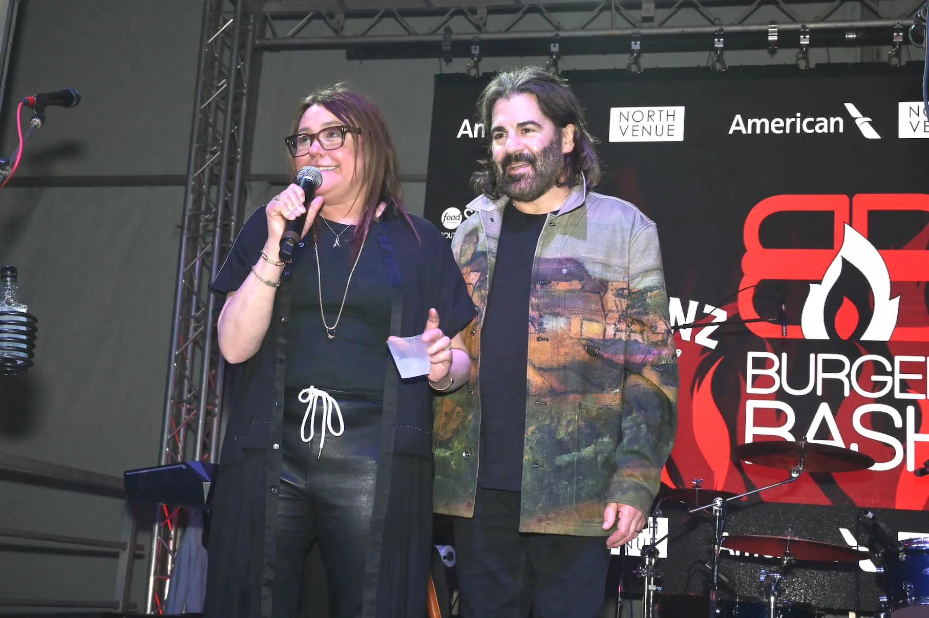 Rachael Ray and husband John Cusimano standing on stage at an event