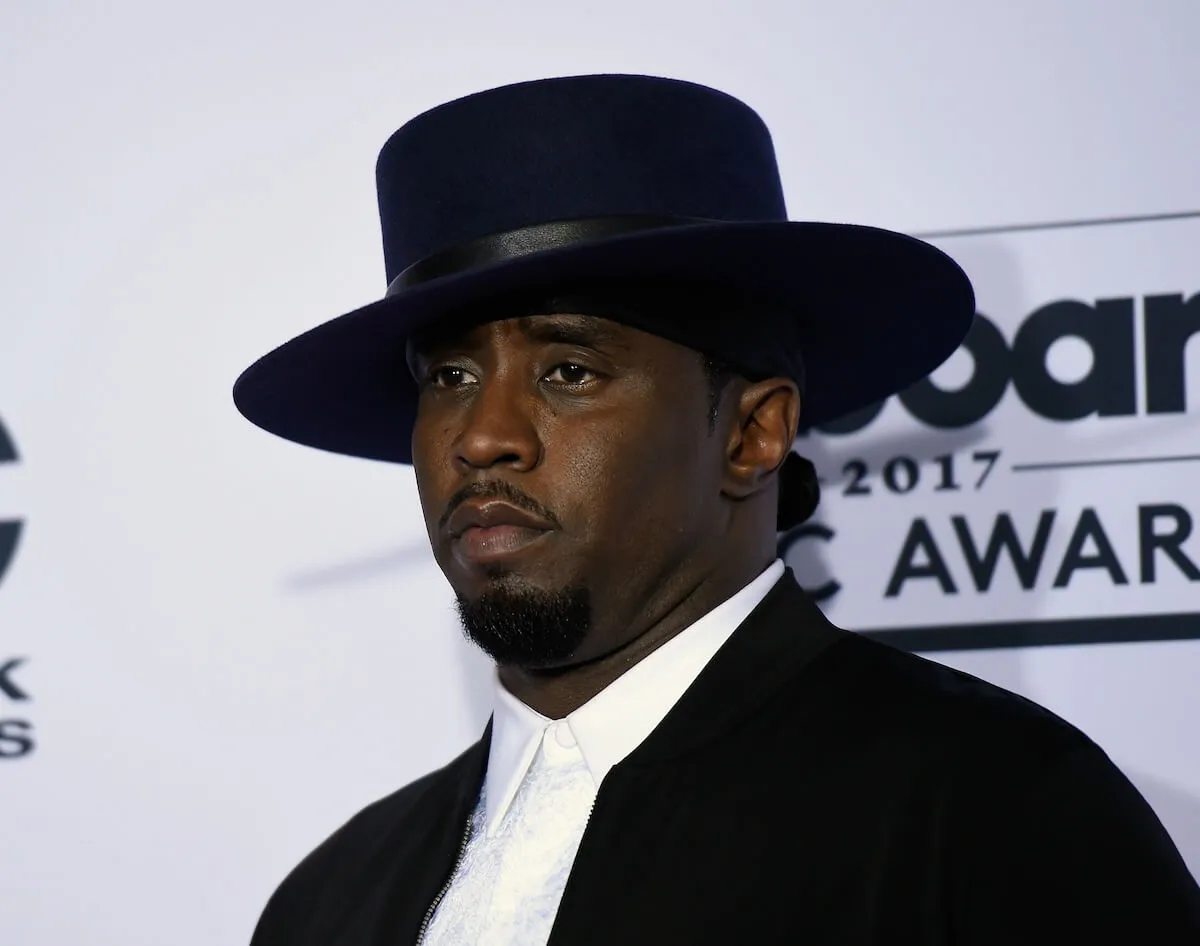 Sean 'Diddy' Combs wears a suit and a wide-brimmed hat.