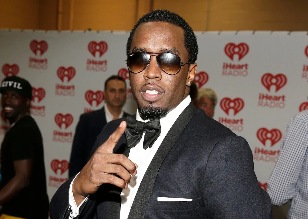 Sean 'Diddy' Combs wears a tuxedo and aviator sunglasses.