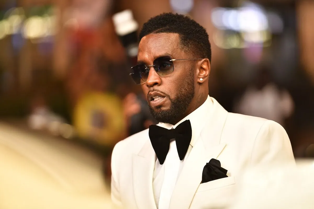 Sean 'Diddy' Combs wears a white tuxedo and sunglasses.