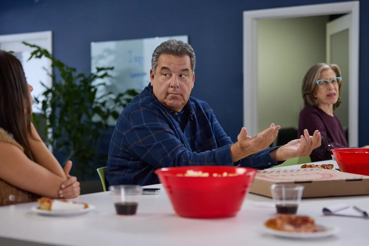 Steve Schrippa sitting at a counter in 'Sisterhood, Inc.'