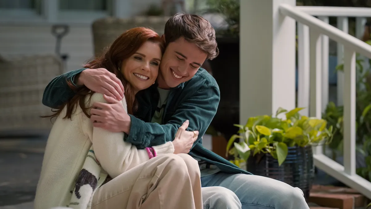 Maddie (JoAnna Garcia Swisher) and Kyle (Logan Allen) embracing on the front porch in 'Sweet Magnolias' Season 4