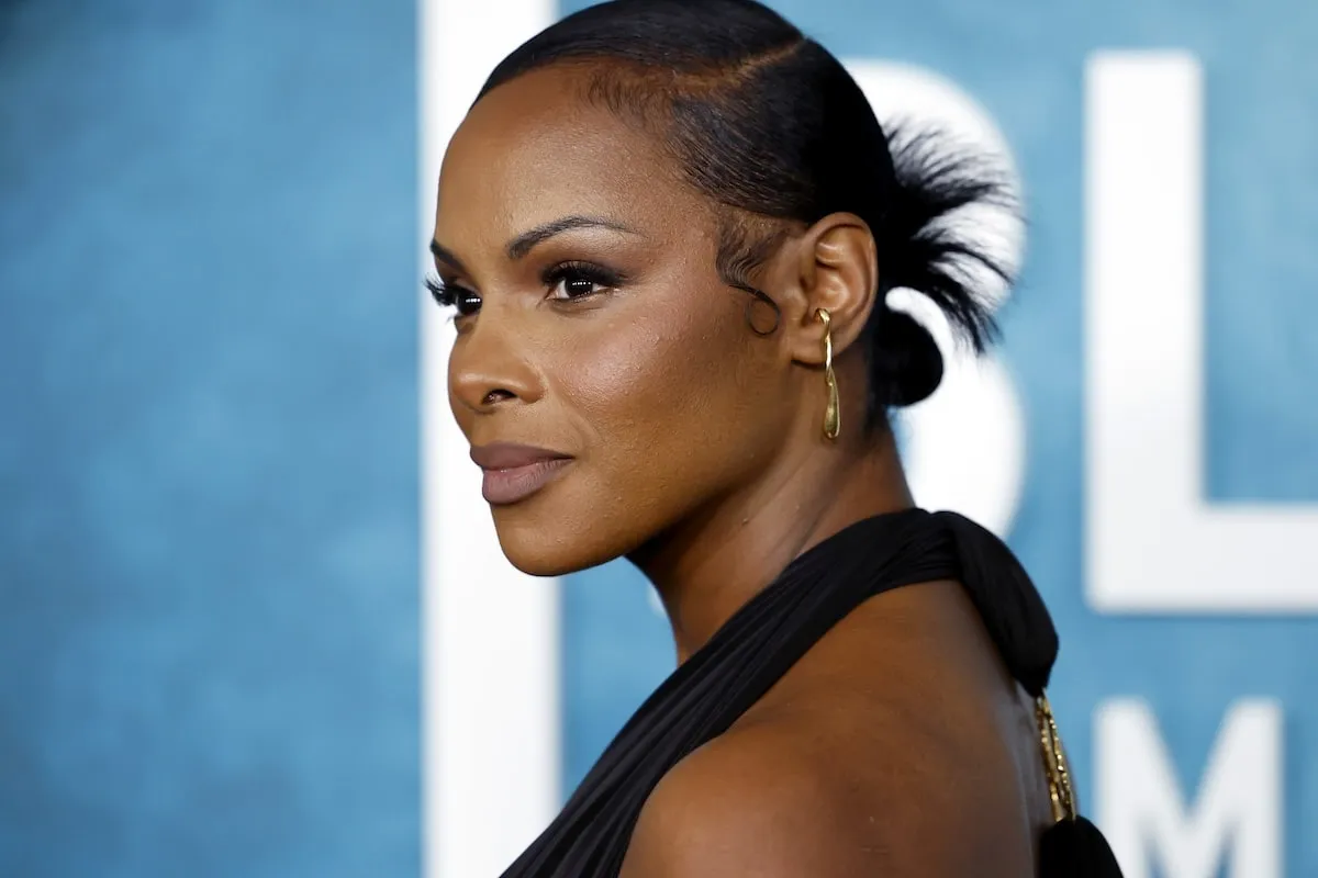 Wearing a black gown with a plunging necklace, Tika Sumper poses for photos while walking the red carpet before the American Black Film Festival