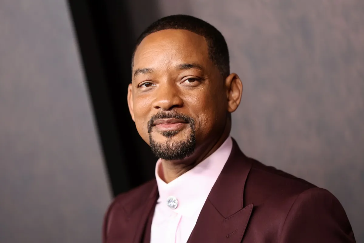 Will Smith posing in a violet suit at the "Emancipation" Los Angeles premiere.